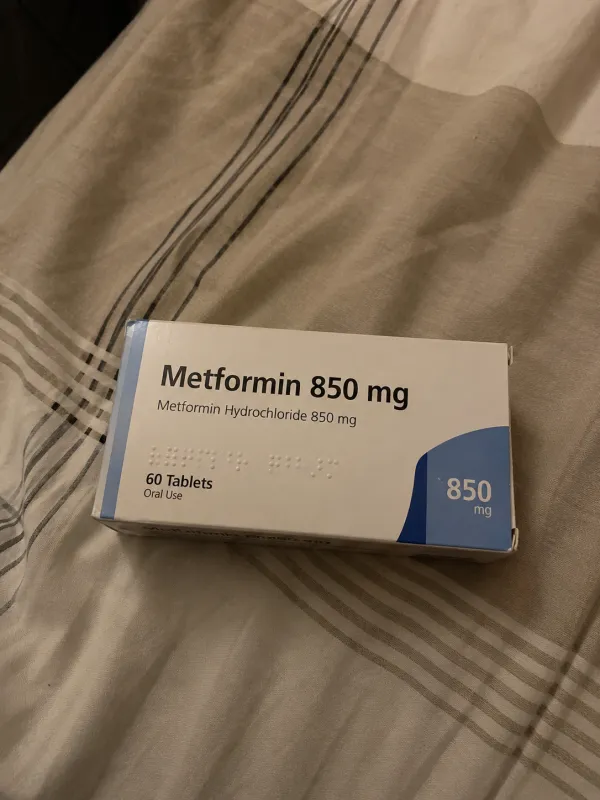 A box of medication photographed on a bed