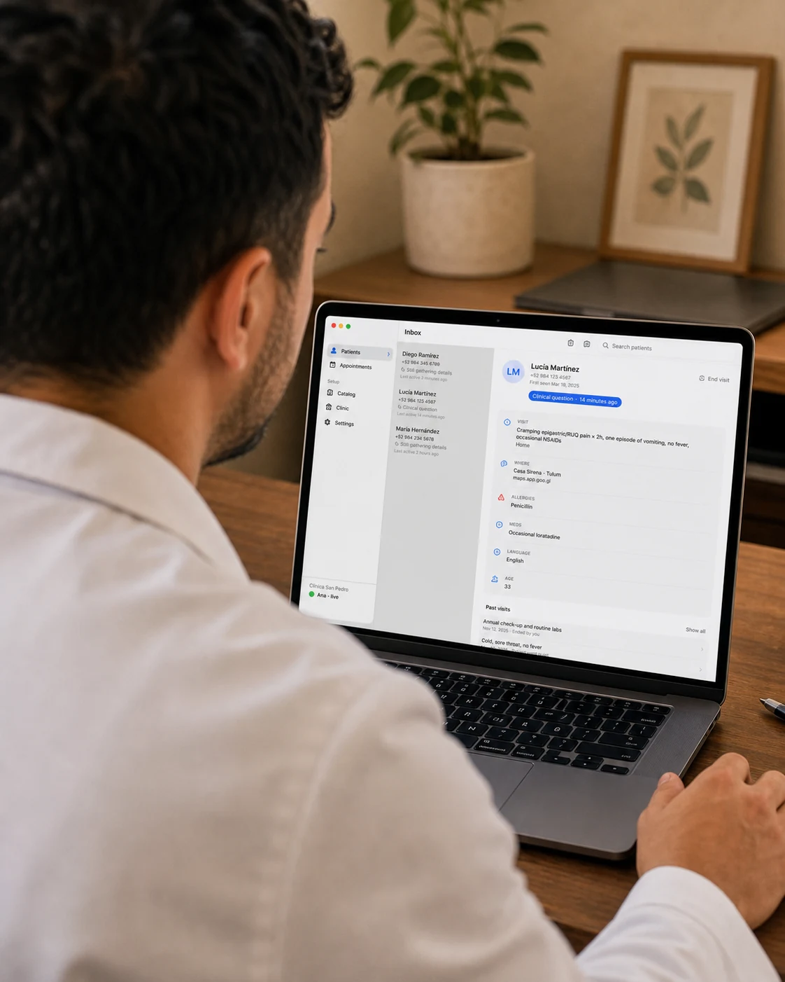Un escritorio de consultorio con luz suave de la tarde, una MacBook abierta trabajando en silencio, sin nadie en la silla