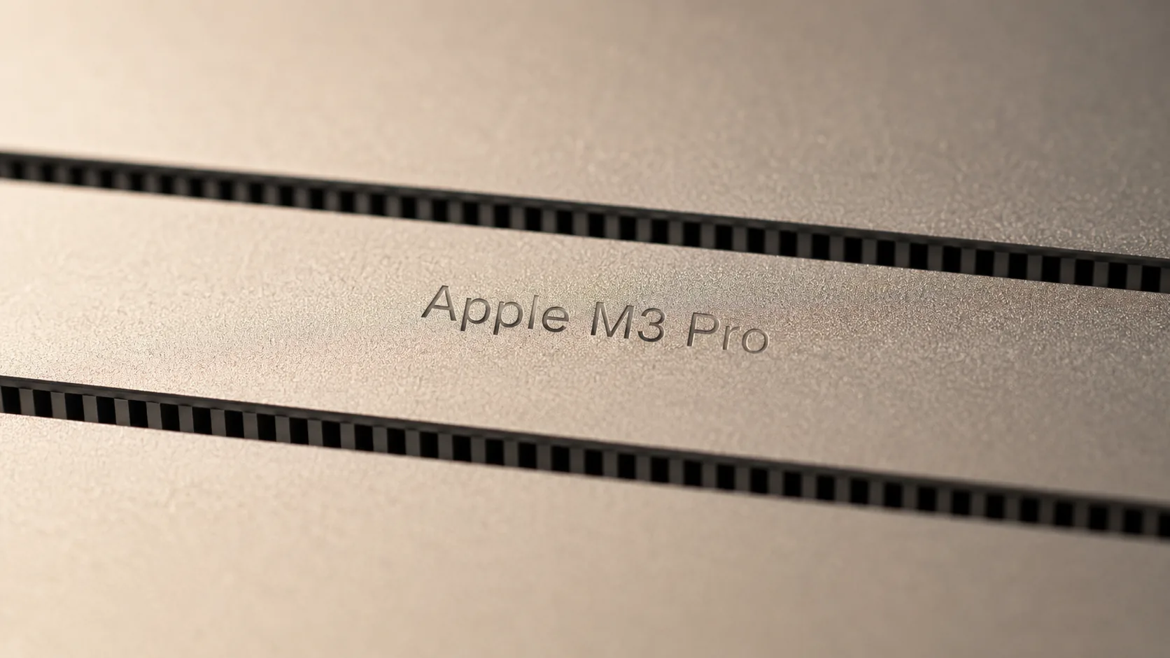Macro close-up of the underside of a MacBook Pro, the etched text Apple M3 Pro visible between two air vent slits